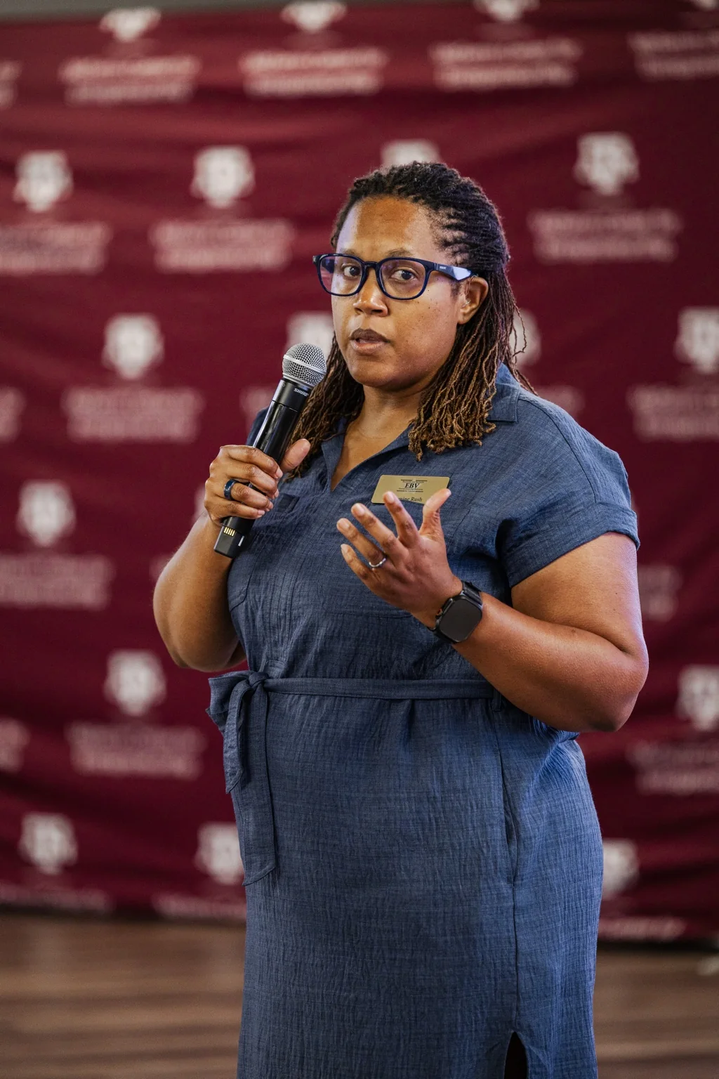 Jasmine speaking into a microphone at an event